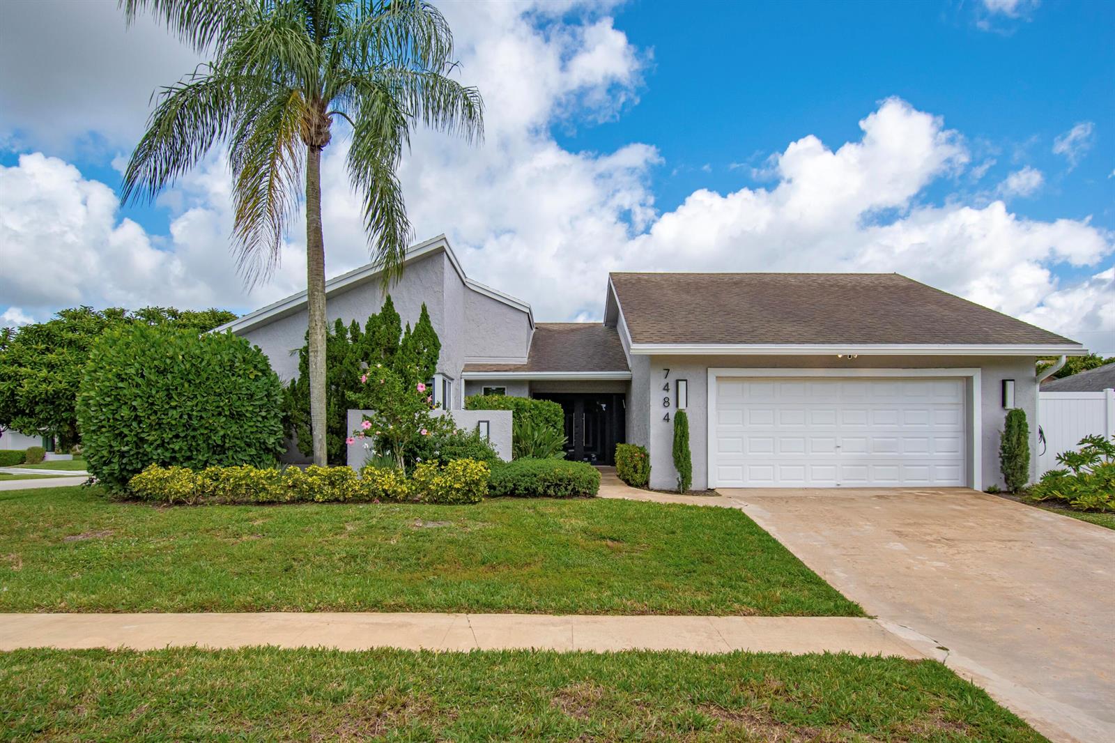A single-story house with a white garage, a palm tree, and a landscaped front yard — 7484 Malibu Crescent, Boca Raton FL 33433, BOCA RATON, FL