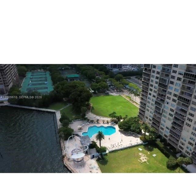 An aerial view shows a swimming pool, green lawn, tennis courts, and a high-rise building — 11111 biscayne blvd # 1815, Miami FL 33181, MIAMI, FL