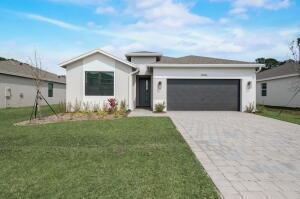 A single-story house with a white exterior, a two-car garage, and a paved driveway — 5946 SE Skyblue Circle, Stuart FL 34997, STUART, FL