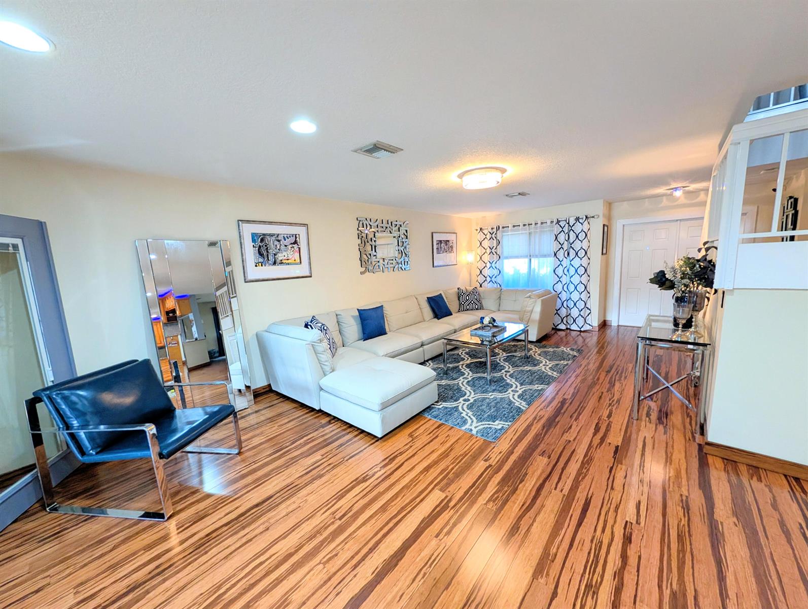 A living room features a white sectional sofa, a blue accent chair, and hardwood floors — 5843 Northpointe Lane, Boynton Beach FL 33437, BOYNTON BEACH, FL