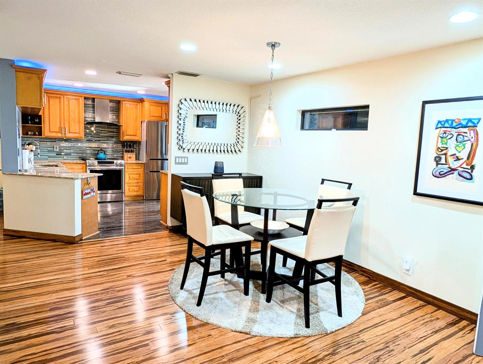 A dining area with a glass table and four chairs sits adjacent to a kitchen — 5843 Northpointe Lane, Boynton Beach FL 33437, BOYNTON BEACH, FL