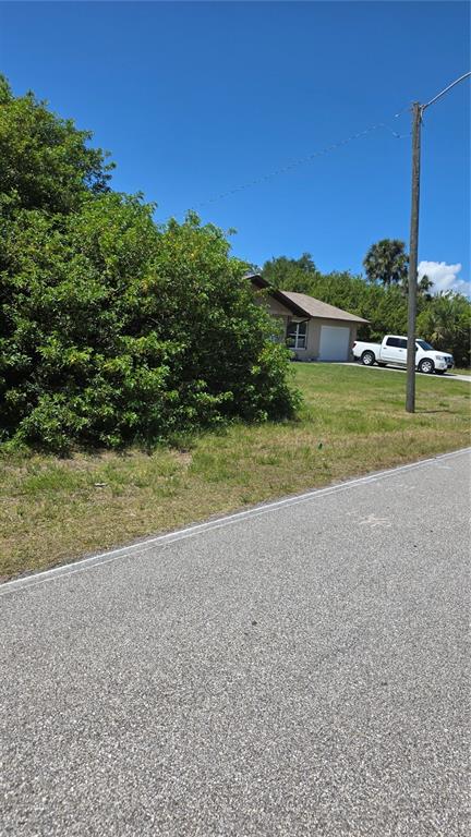 A house with a white truck parked in the driveway sits behind a large bush — 509 ORANGE DRIVE NW, PORT CHARLOTTE, FL