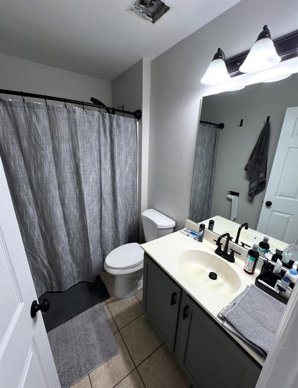 A bathroom features a vanity with a gray cabinet, a toilet, and a shower curtain — 4020 STONEFIELD DRIVE, ORLANDO, FL