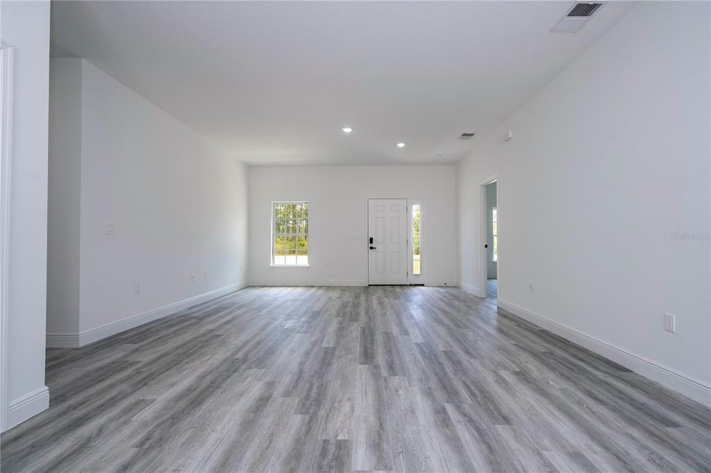 An empty room with white walls, recessed lighting, and gray wood-look flooring — 2580 GALLARDIA DRIVE, INDIAN LAKE ESTATES, FL