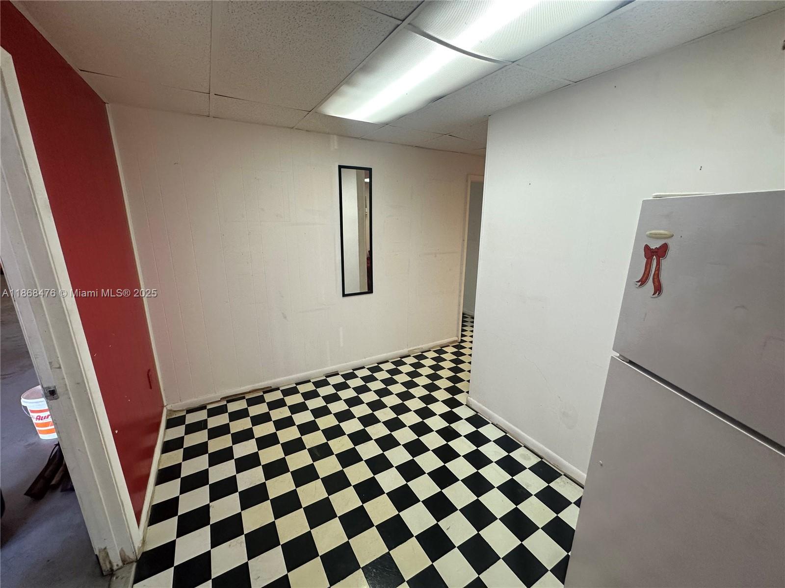 A room with white walls, a black and white checkered floor, and a refrigerator — 4115 NW 132nd St, Opa-Locka FL 33054, OPA-LOCKA, FL