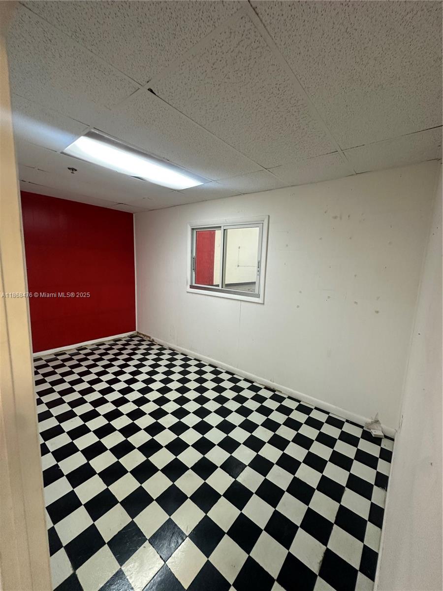 A small room features a black and white checkered floor, white walls, and one red wall — 4115 NW 132nd St, Opa-Locka FL 33054, OPA-LOCKA, FL