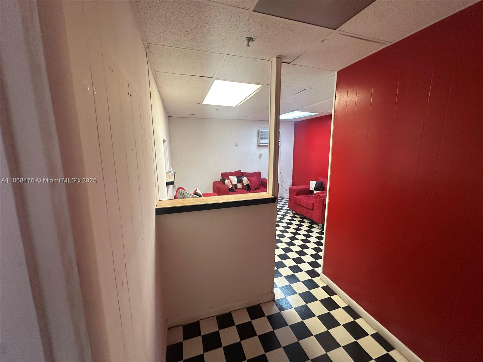 A room features a black and white checkered floor, red walls, and red sofas — 4115 NW 132nd St, Opa-Locka FL 33054, OPA-LOCKA, FL