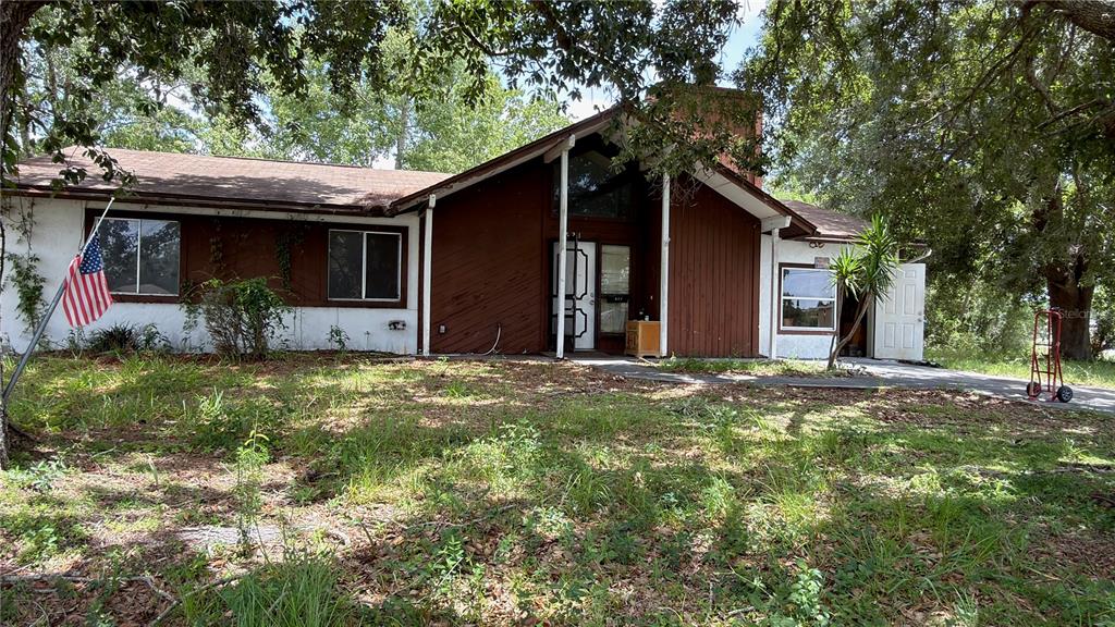 A single-story house with brown wood siding, a white stucco section, and a front porch — 621 ELDRON BOULEVARD SE, PALM BAY, FL