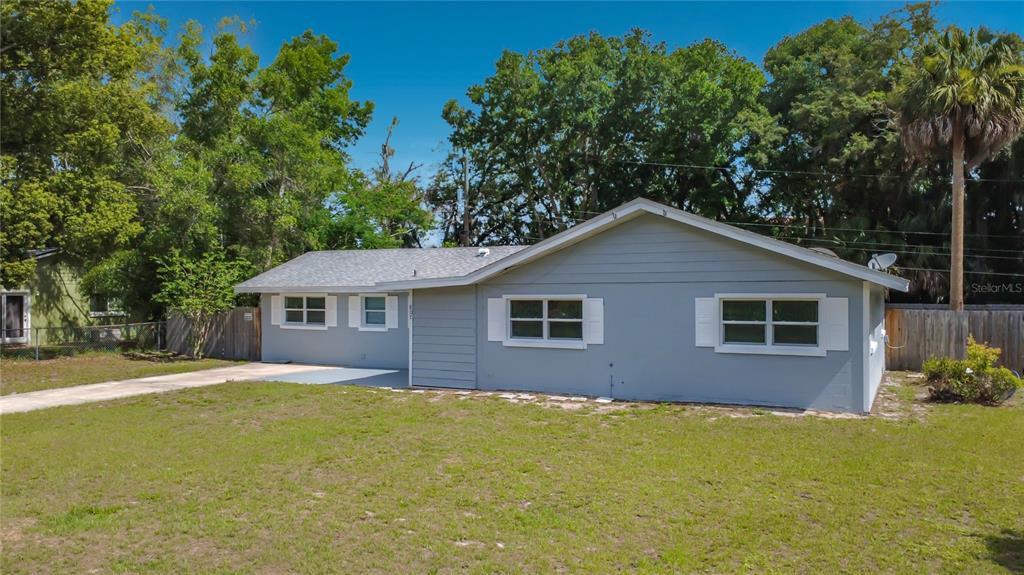 A single-story gray house with a white-trimmed window and a concrete driveway — 807 CHEROKEE CIRCLE, SANFORD, FL