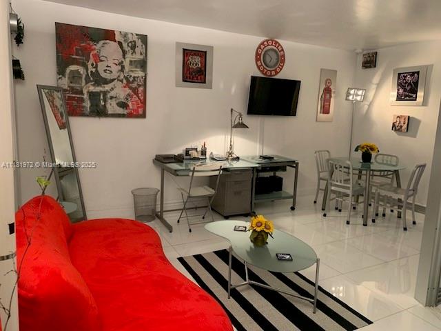 A living room features a red sofa, a desk, a dining set, and wall art — 100 LINCOLN RD # 1509, Miami Beach FL 33139, MIAMI BEACH, FL