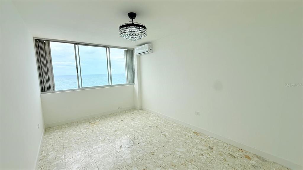 An empty room with light-colored terrazzo flooring, a crystal ceiling fan, and ocean views — 0 ASHFORD AVE UNIT 1207, CONDADO, PR