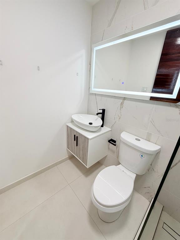 A modern bathroom features a floating vanity, vessel sink, toilet, and an illuminated mirror — 0 ASHFORD AVE UNIT 1207, CONDADO, PR