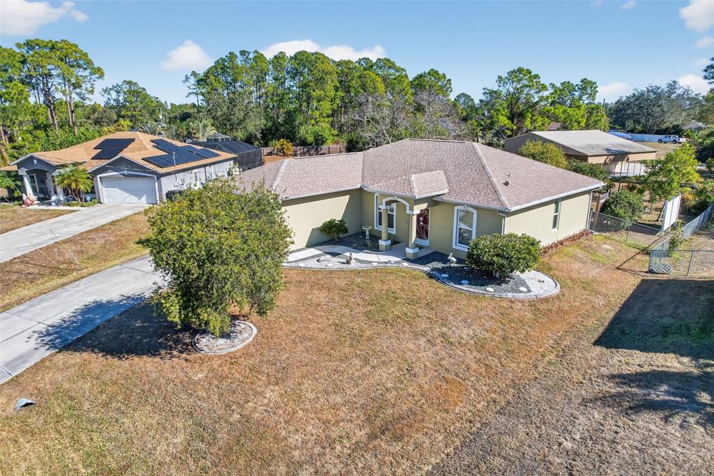 An aerial view shows a single-story house with a tan exterior and a shingled roof — 7888 EVINRUDE AVENUE, NORTH PORT, FL