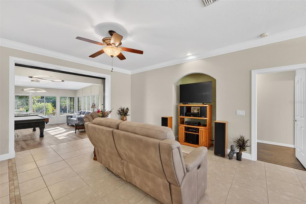 A living room with tile floors, a ceiling fan, and an arched television alcove — 7888 EVINRUDE AVENUE, NORTH PORT, FL