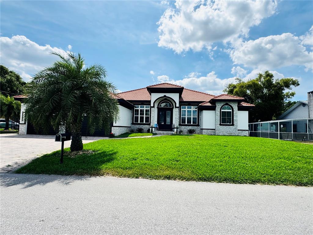A single-story house with a tiled roof, white stucco walls, and stone accents — 803 LAKE JESSIE DR DRIVE, WINTER HAVEN, FL