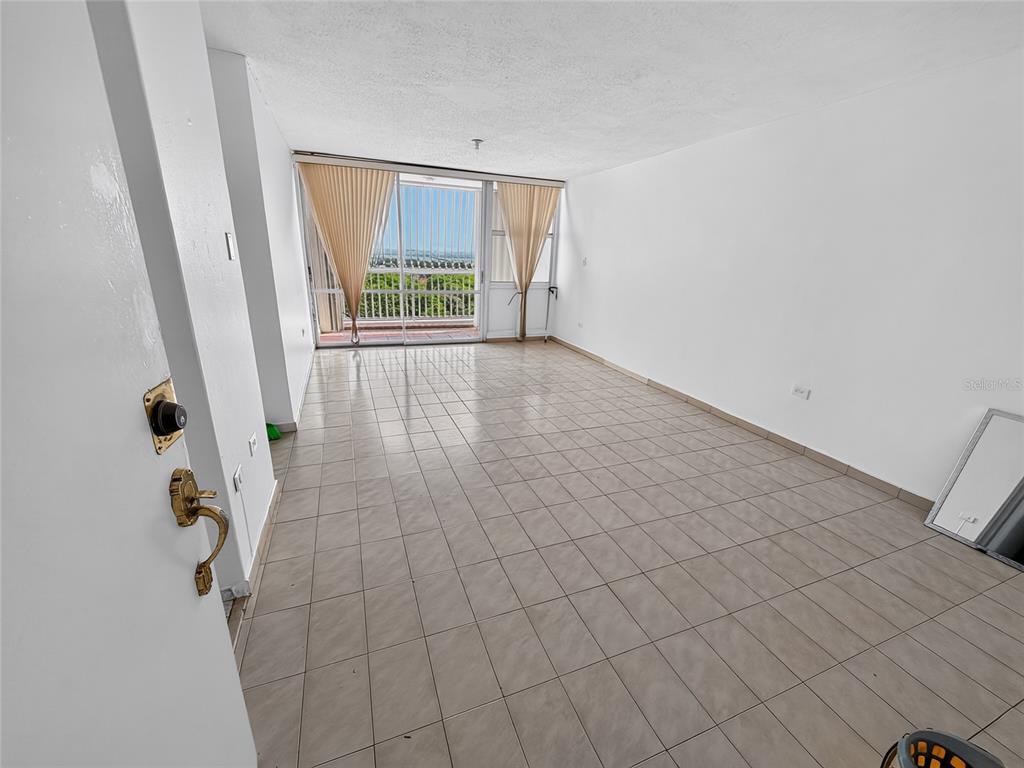 An empty room with light-colored tile flooring, white walls, and a sliding glass door balcony — 444 CONDOMINIO DE DIEGO UNIT 1503, SAN JUAN, PR