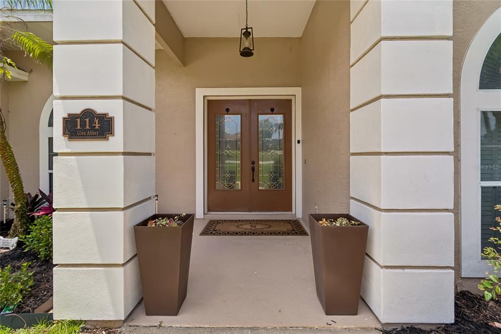 A front entryway features a double door with glass inserts between two large white pillars — 114 GLEN ABBEY LANE, DEBARY, FL