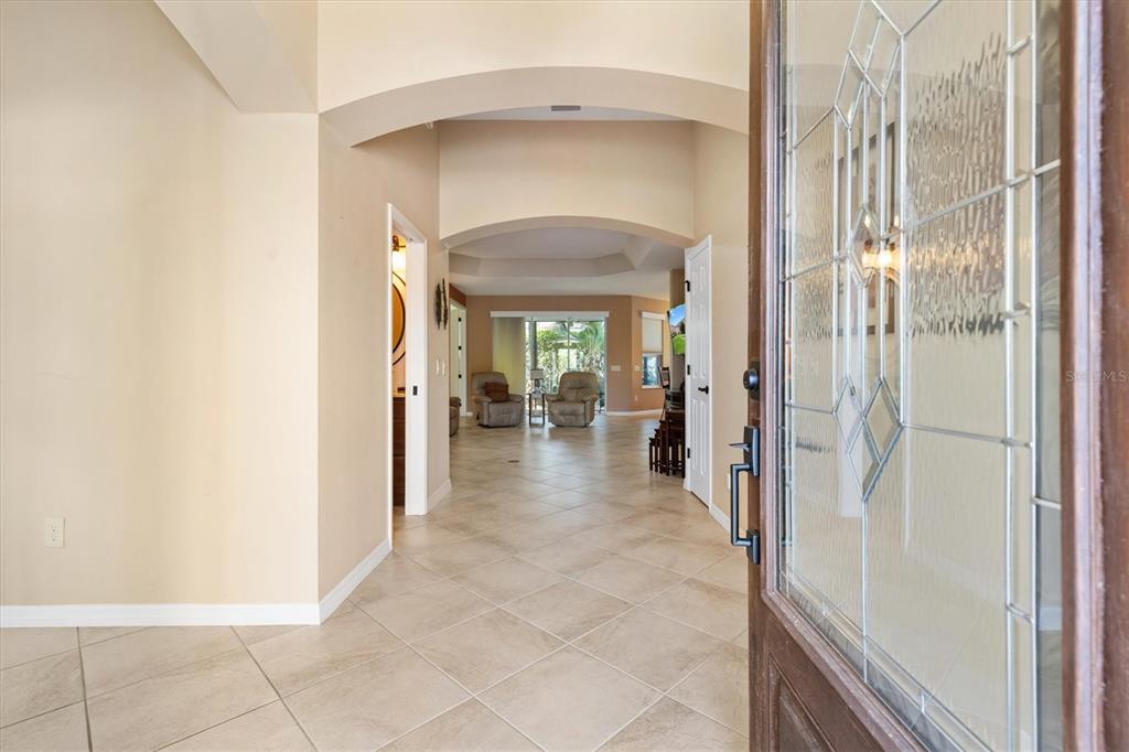 A view from an open front door into a tiled foyer leading to a living area — 1304 BRUNELL STREET, THE VILLAGES, FL