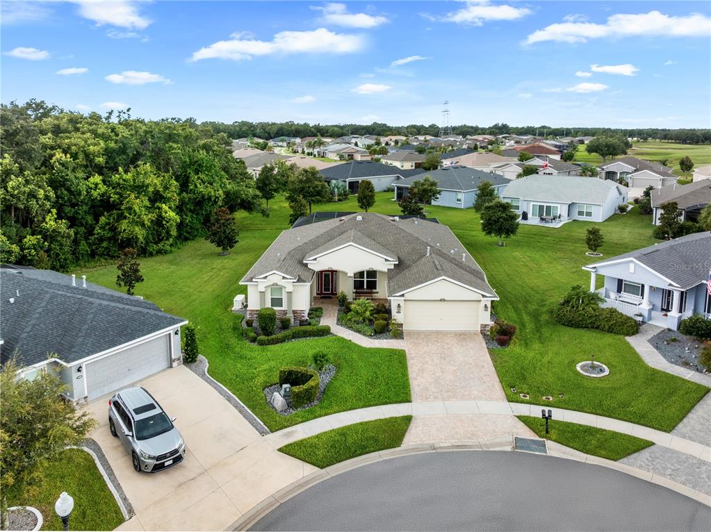 An aerial view shows a single-story suburban house with a paved driveway and green lawn — 4419 BENT CREEK LANE, LEESBURG, FL