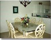 A dining area features a glass-topped table with four chairs and a chandelier — 5270 HYLAND HILLS AVENUE UNIT 1722, SARASOTA, FL