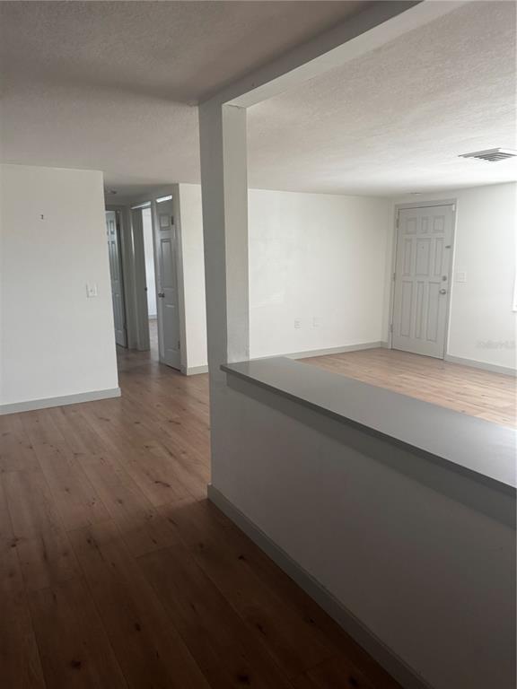 A view from a kitchen counter looking toward a living area and hallway with doors — 5253 DEVRIES DRIVE, NEW PORT RICHEY, FL