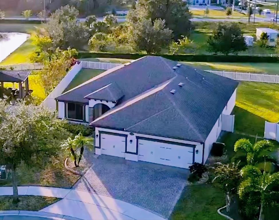 An aerial view shows a single-story house with a gray roof and a paved driveway — 5121 APPENINE LOOP W, ST CLOUD, FL