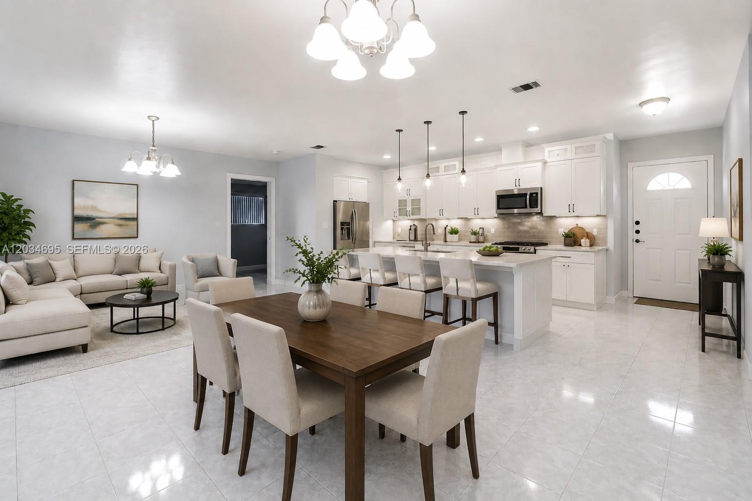 An open-concept kitchen, dining area, and living room feature white cabinetry and tile flooring — 9120 SW 16th St, Miami FL 33165, MIAMI, FL
