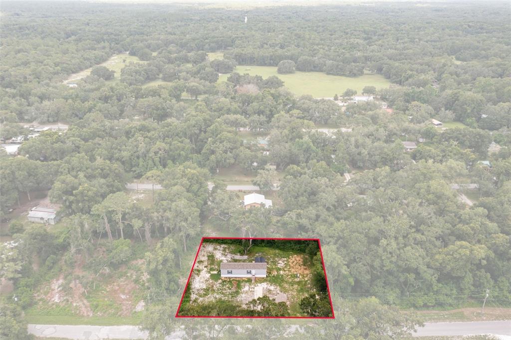 An aerial view shows a single-story house on a rectangular lot surrounded by trees — 4363 CR 690, WEBSTER, FL