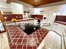 A kitchen features a large island with a black cooktop and red tiled countertops — 2351 SW 92nd Pl, Miami FL 33165, MIAMI, FL