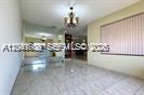 A bright room with light-colored tile flooring, a chandelier, and a large window with blinds — 2351 SW 92nd Pl, Miami FL 33165, MIAMI, FL