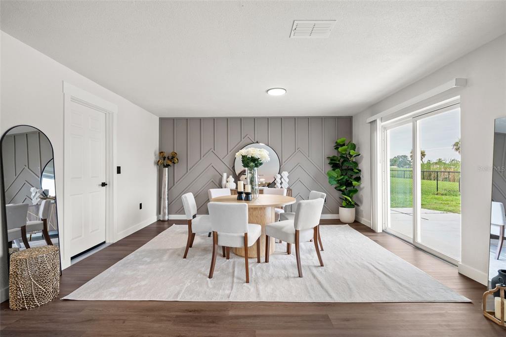 A dining room features a round table, upholstered chairs, and a grey chevron-patterned accent wall — 30 OAKLAND HILLS COURT, ROTONDA WEST, FL