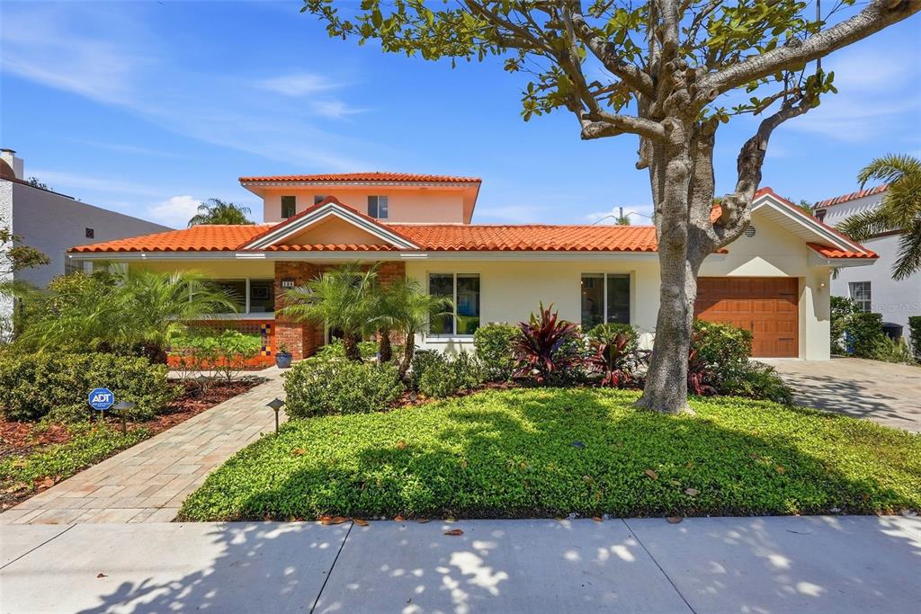 A single-story house with a terracotta tile roof, brick accents, and a paved walkway — 125 23RD AVENUE NE, ST PETERSBURG, FL