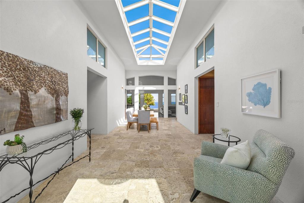 A bright foyer with a skylight, stone flooring, and a view of the ocean — Lot 4 IBIZA ST, RD 107 KM 2.7, AGUADILLA, PR