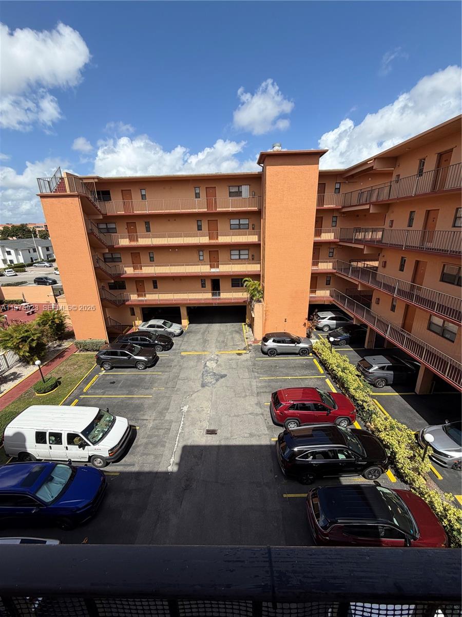 An elevated view shows an orange multi-story apartment building with an open-air parking lot — 1800 W 54th St # 309, Hialeah FL 33012, HIALEAH, FL