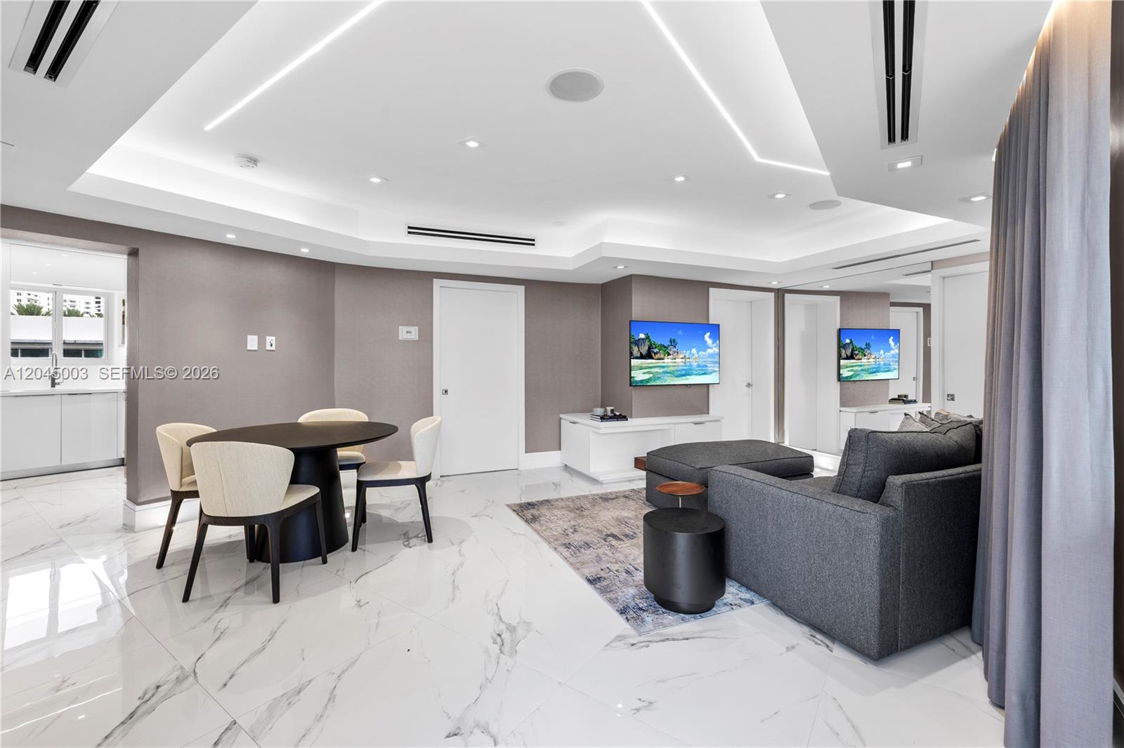 A modern living and dining area features white marble floors, recessed lighting, and gray furniture — 10190 Collins Ave # 203, Bal Harbour FL 33154, BAL HARBOUR, FL