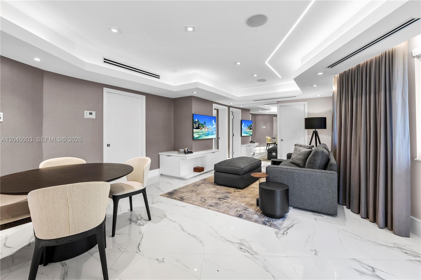 A modern living and dining area features marble floors, recessed lighting, and gray furniture — 10190 Collins Ave # 203, Bal Harbour FL 33154, BAL HARBOUR, FL