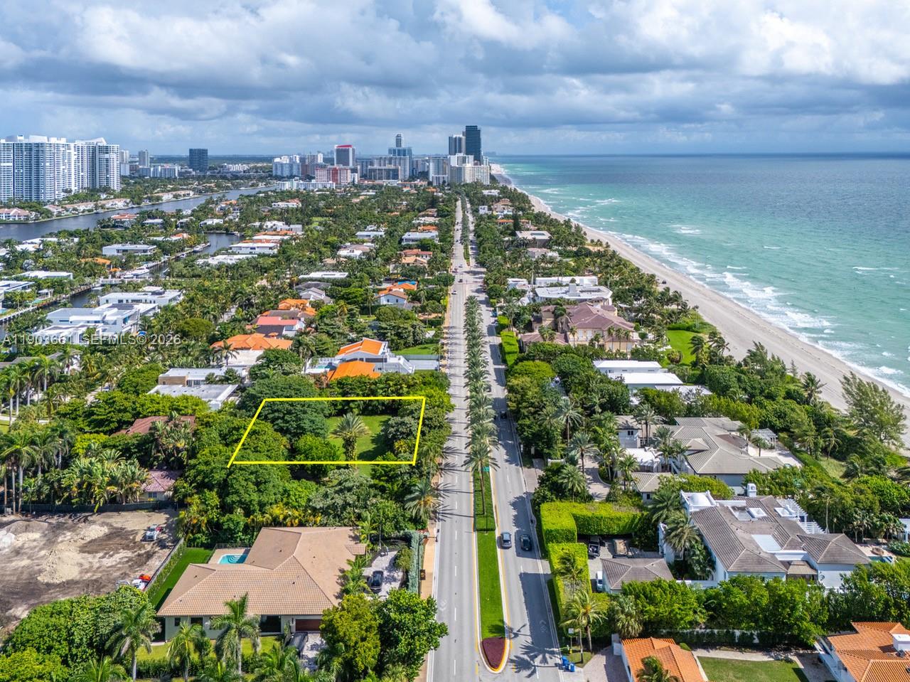An aerial view shows a vacant, tree-filled lot outlined in yellow along a coastal road — 326 Ocean Blvd, Golden Beach FL 33160, GOLDEN BEACH, FL