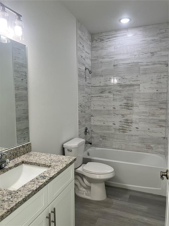 A bathroom features a vanity with a granite countertop, a toilet, and a tiled tub-shower — 3467 W SEAHORSE LANE, CITRUS SPRINGS, FL