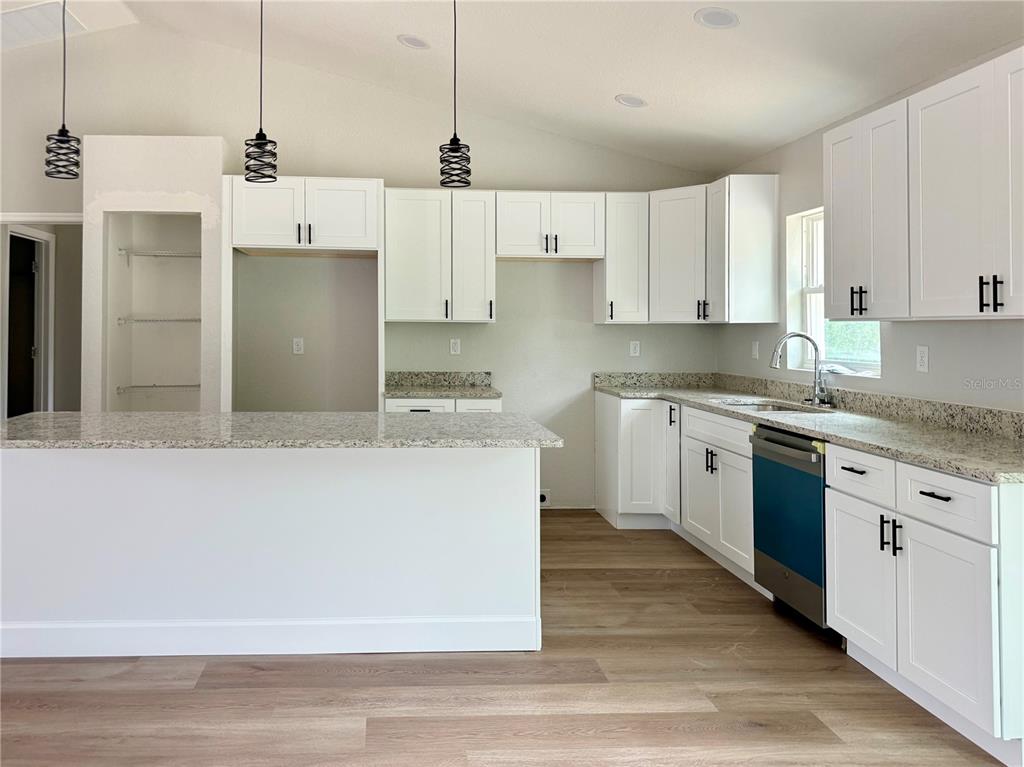 A kitchen with white cabinets, granite countertops, a center island, and stainless steel appliances — 1531 NE 153RD AVENUE, WILLISTON, FL
