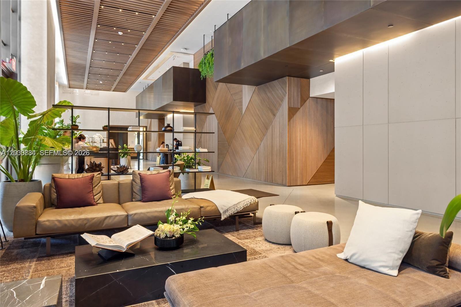 A modern kitchen features dark wood cabinetry, stainless steel appliances, and a light-colored stone countertop — 159 NE 6th St, Miami FL 33132, MIAMI, FL