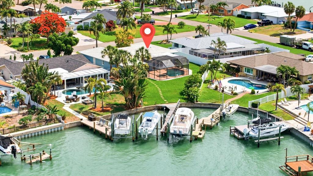 An aerial view shows waterfront houses with private pools and boat docks along a canal — 8008 13TH AVENUE S, ST PETERSBURG, FL