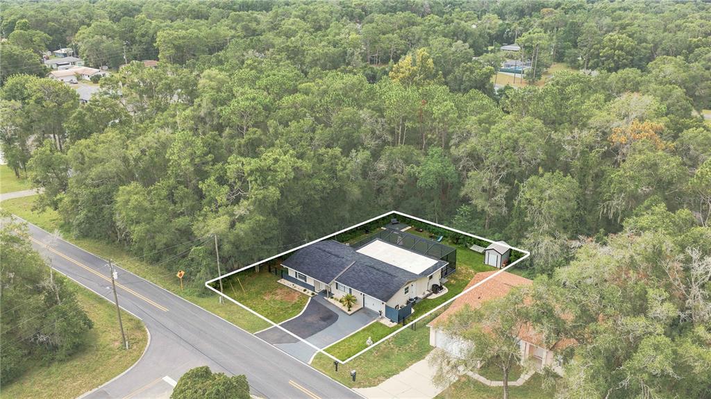 An aerial view shows a single-story house with a pool enclosure and a fenced yard — 221 E INVERNESS  BOULEVARD, INVERNESS, FL