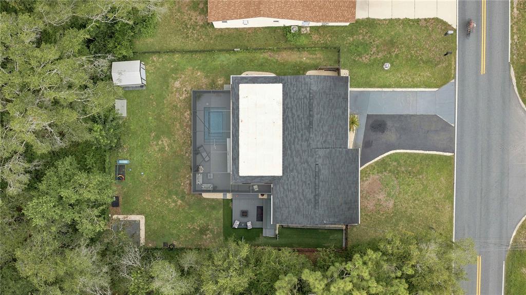 An aerial view shows a house with a screened pool enclosure and a backyard — 221 E INVERNESS  BOULEVARD, INVERNESS, FL