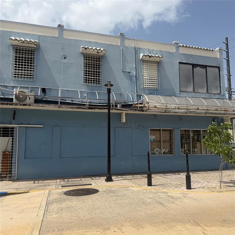 A two-story blue building features a metal awning, security bars on windows, and a streetlamp — AVE. COMERIO ESQ. BETANCES, BAYAMON, PR