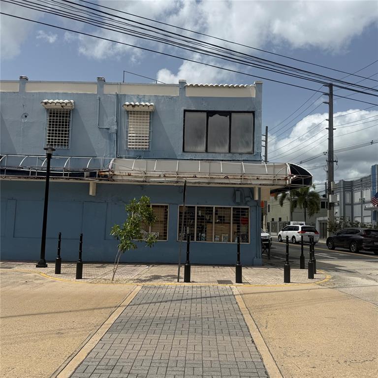 A two-story blue building with a metal awning and street-level windows on a corner lot — AVE. COMERIO ESQ. BETANCES, BAYAMON, PR