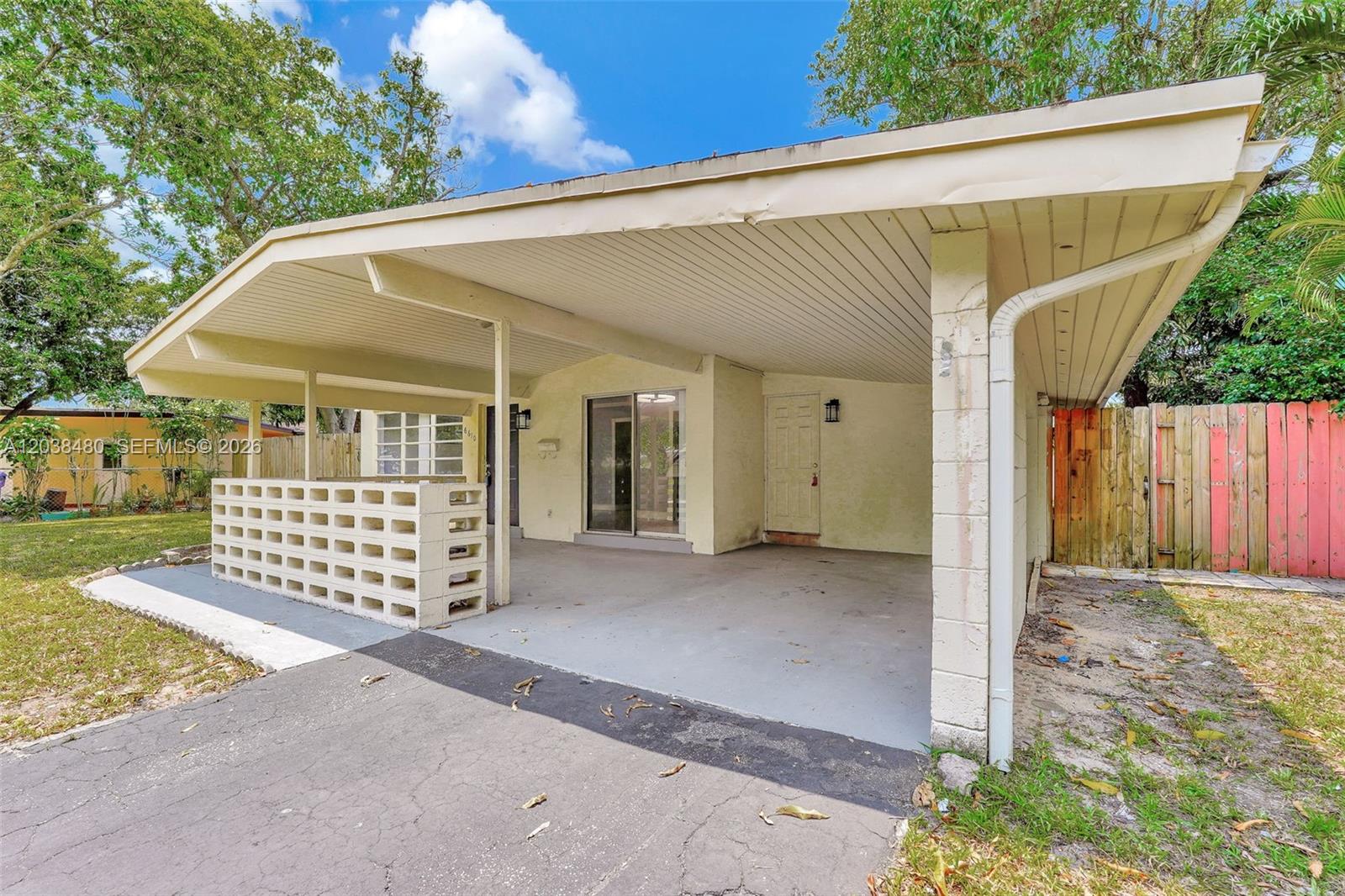 A house exterior features a large covered carport with a concrete floor and block wall — 6610 Johnson St, Hollywood FL 33024, HOLLYWOOD, FL