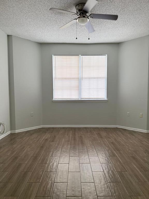 An empty room with light gray walls, wood-look tile flooring, and a ceiling fan — 10831 WINDSOR WALK DRIVE UNIT 311, ORLANDO, FL