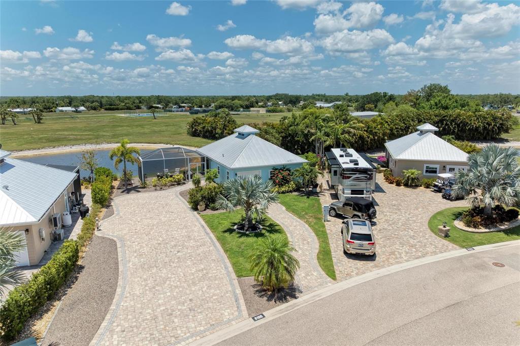 An aerial view shows two houses with metal roofs, paved driveways, and an RV parked outside — 8196 SW SAND CRANE CIRCLE LOT 96, ARCADIA, FL