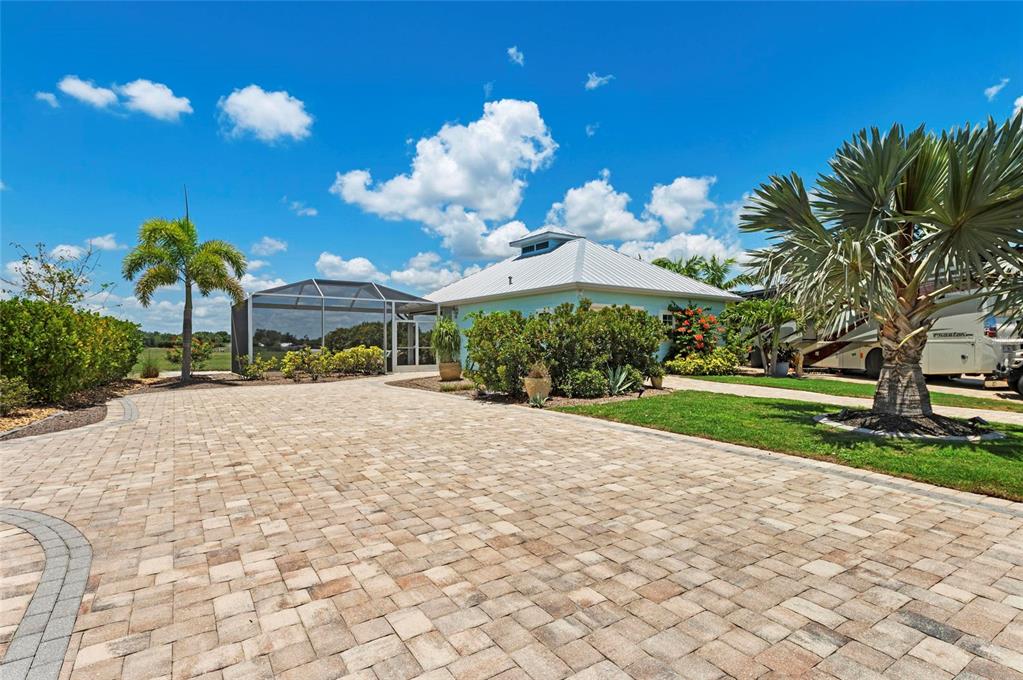 A paved driveway leads to a light blue house with a screened-in pool enclosure — 8196 SW SAND CRANE CIRCLE LOT 96, ARCADIA, FL