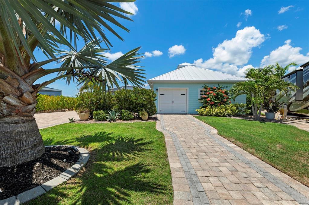 A light blue detached garage with a white metal roof sits behind a brick walkway — 8196 SW SAND CRANE CIRCLE LOT 96, ARCADIA, FL